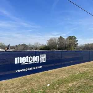 Metcon branded 9 oz mesh fence wrap with logo and QR code on construction site fence