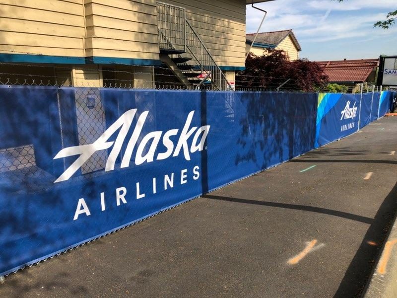 Alaska Airlines full-color printed fence wrap along a sidewalk