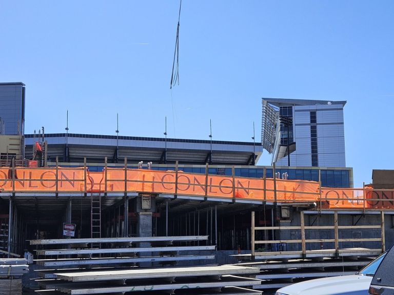 Orange debris safety netting printed with a contractor logo