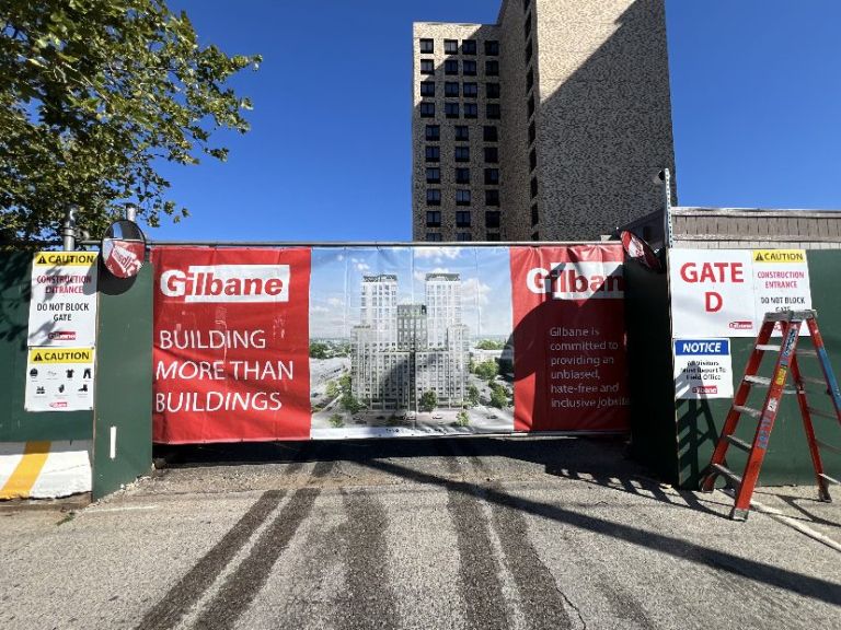Contractor-branded banner on a construction site gate