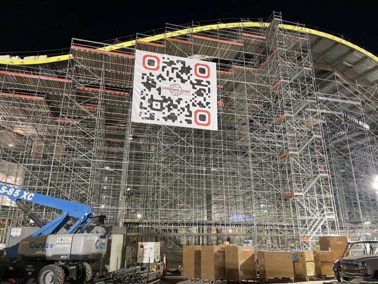 Oversized banner with QR code mounted on scaffolding