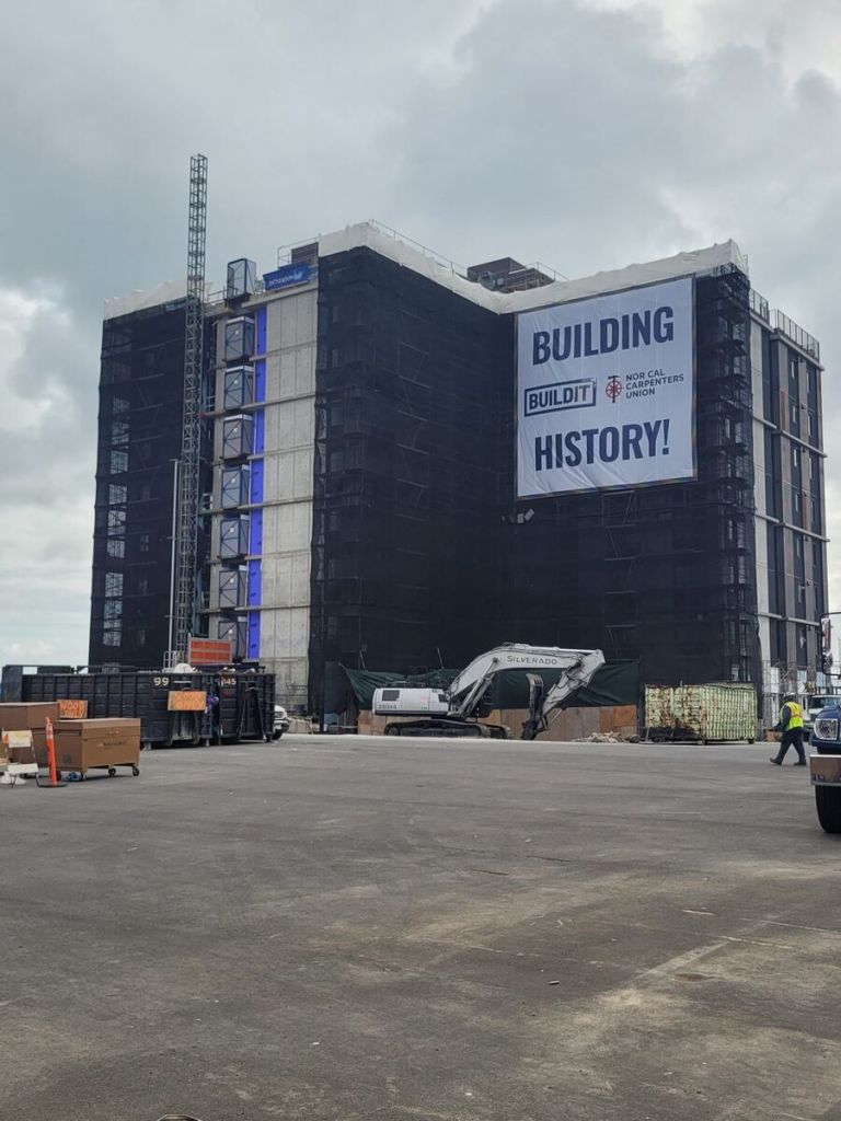 Oversized Building History banner for Nor Cal Carpenters Union on a scaffold-wrapped high-rise