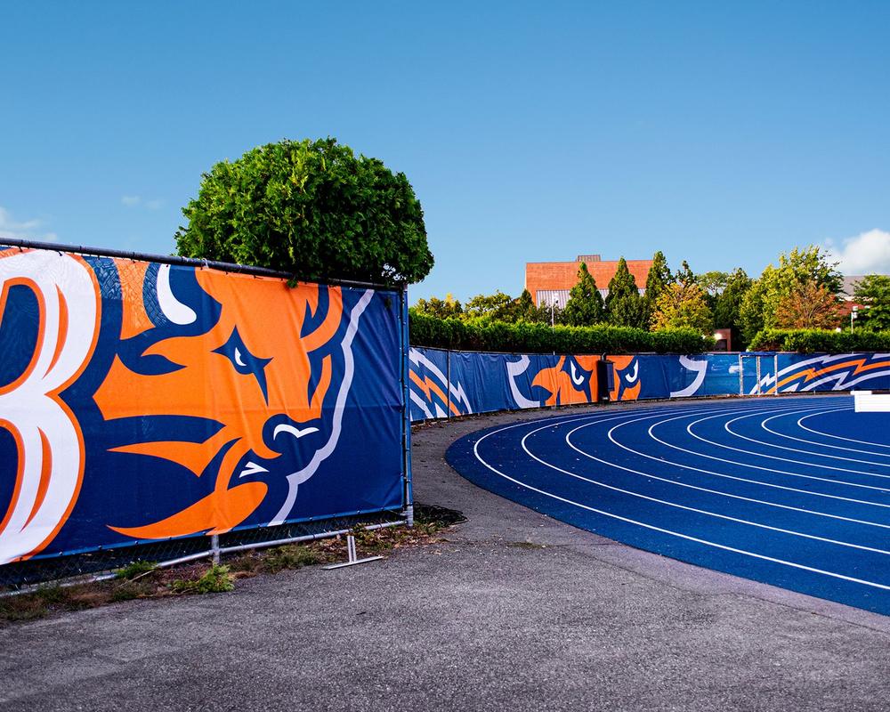 Custom printed athletic windscreen on a stadium track fence